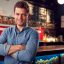 portrait of male bar owner standing by counter image